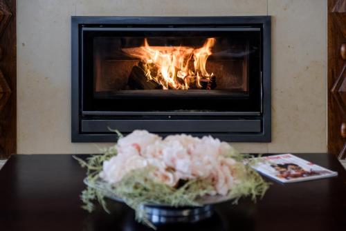 a fireplace with flowers on a table in front of it at Hotel Regina in Fátima