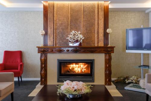 a living room with a fireplace and a tv at Hotel Regina in Fátima