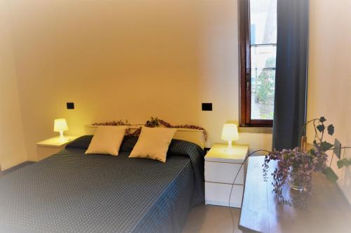 una camera da letto con un letto con due lampade e una finestra di Baia Etrusca Resort a Riotorto