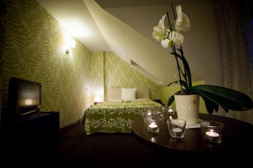 a hotel room with a bed and a vase with flowers at Gościniec Nad Gopłem in Grodztwo