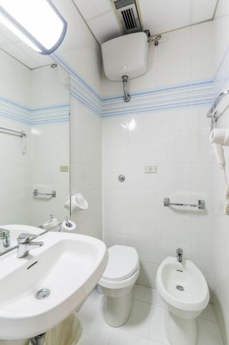 a white bathroom with a sink and a toilet at Hotel Rex in Florence