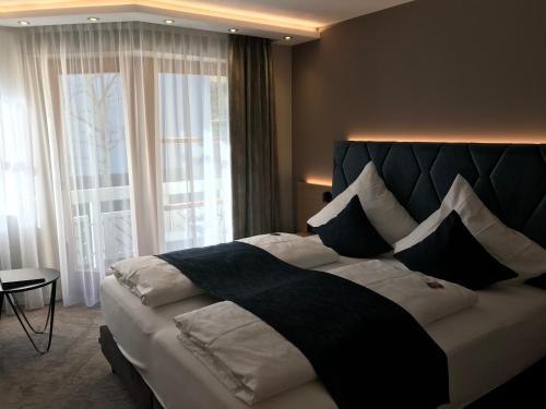a bedroom with a large bed with a large window at Hotel Garni Villa Rosengarten in Überlingen