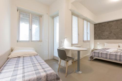 1 Schlafzimmer mit 2 Betten, einem Schreibtisch und einem Tisch in der Unterkunft B&B Open Doors Verona in Verona
