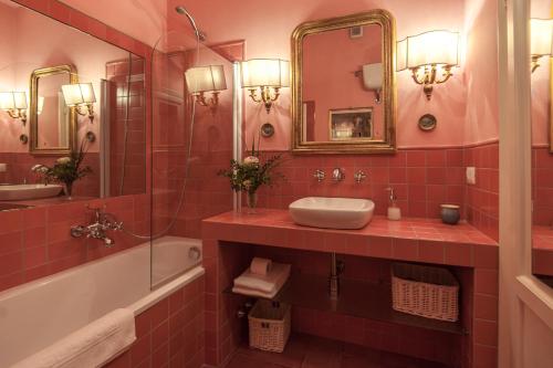 a red tiled bathroom with a sink and a tub at Casa Schlatter in Florence