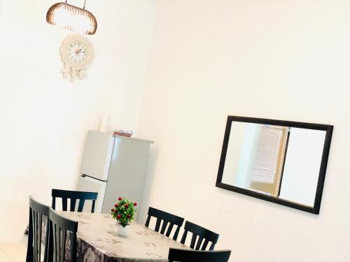 a kitchen with a table and chairs and a mirror at Homestay Cahaya 1 Seri Iskandar in Seri Iskandar