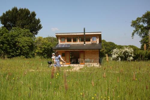 two people and a dog in front of a house at Tiny Home cabin Eilidh in Cowes