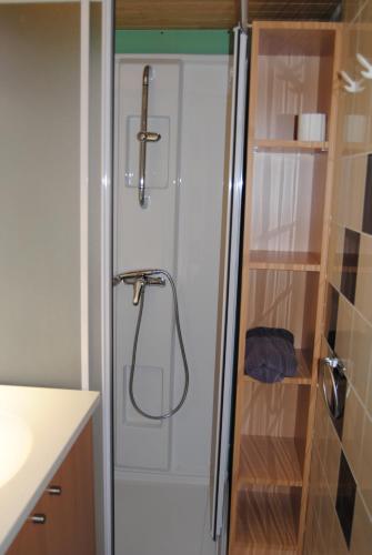 um chuveiro com uma porta de vidro na casa de banho em moulin de rouchillou em Saint-Martial-de-Valette