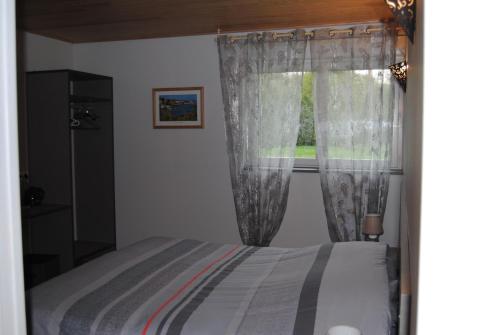 um quarto com uma cama e uma janela em moulin de rouchillou em Saint-Martial-de-Valette