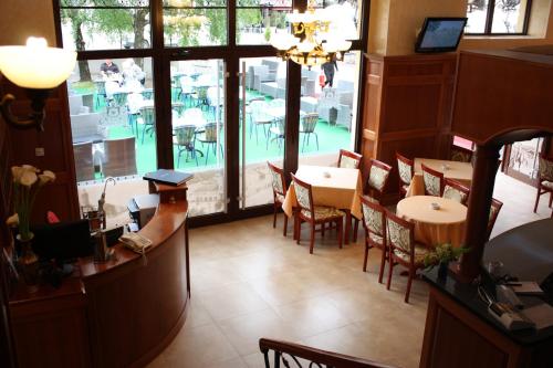 a restaurant with tables and chairs and a large window at Garni Hotel Beograd in Negotin