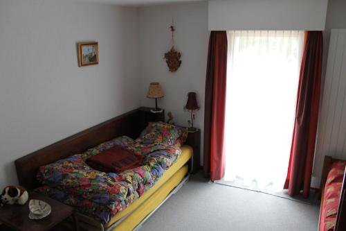 1 dormitorio con cama y ventana en Big flat in the heart of Valais, en Martigny-Combe