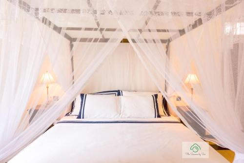 a bedroom with a canopy bed with white curtains at Headman House Antique Villa - Ahangama in Ahangama