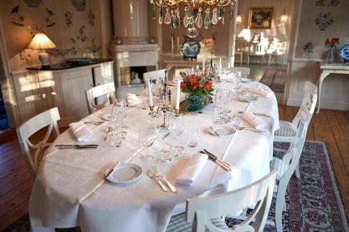 a long table with white tablecloths and napkins at Tofta Herrgård in Lycke