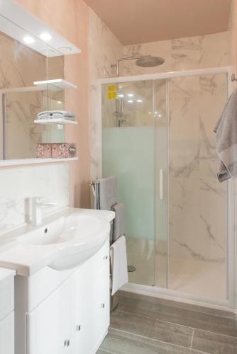 une salle de bain avec un lavabo blanc et une douche dans l'établissement Appartement Duplex Totalement Meublé et Équipé, à Lignières