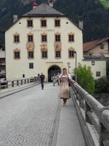 a woman standing on a bridge in front of a building at Apart Romantica in Pfunds