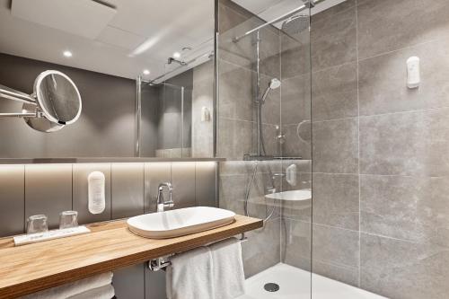 a bathroom with a shower, sink, and toilet at H+ Hotel Bremen in Bremen