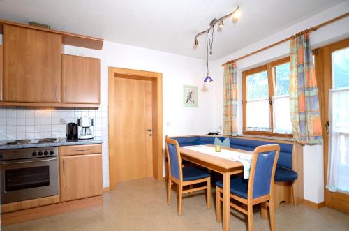 a kitchen with a table and chairs in a room at Apart Romantica in Pfunds