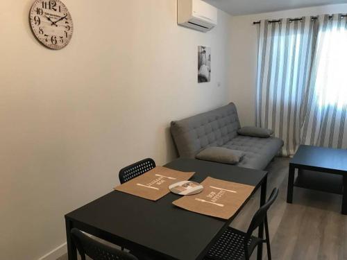 - un salon avec une table, un canapé et un réveil dans l'établissement Corté Centre Corse, à Corte