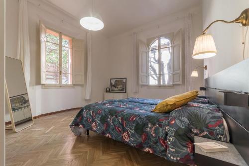 una camera con un letto e un tavolo e due finestre di Tilia a Bologna