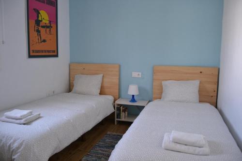 dwa łóżka siedzące obok siebie w pokoju w obiekcie Casa "La Breña". Surf,sol y relax. w mieście Los Caños de Meca