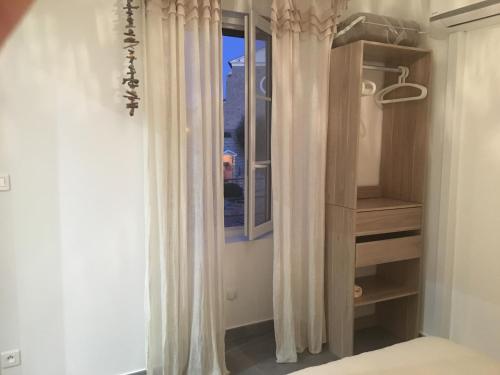 une chambre avec un lit et une fenêtre avec des rideaux dans l'établissement CasaRadriimas, un cocon au cœur du Centre Ville, à Propriano