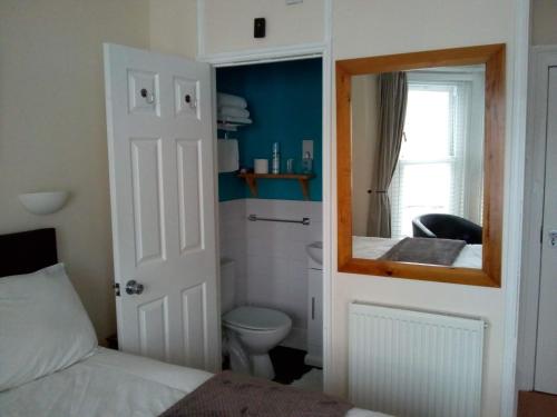 グレート・ヤーマスにあるSeamore Guest Houseのバスルーム(ベッド1台、鏡、トイレ付)