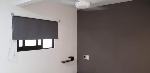 a room with a window and a television on the wall at El Suburbio - Morelos Sur in Morelia