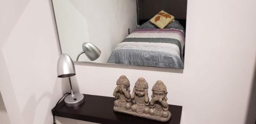 a small bedroom with a bed and a mirror at El Suburbio - Morelos Sur in Morelia