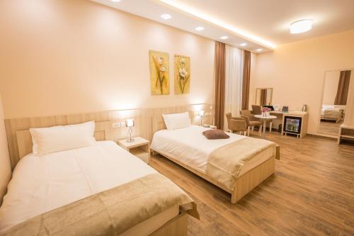 a bedroom with two beds and a living room at Hotel Mar Garni in Belgrade