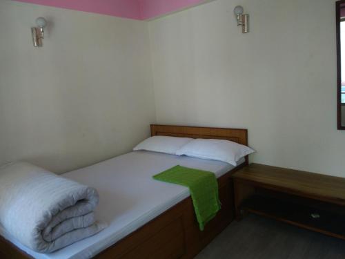 a small bedroom with two beds and a green towel at Big Bell Guest House in Bhaktapur