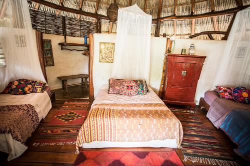 a bedroom with two beds in a room at Present Moment Retreat in Troncones