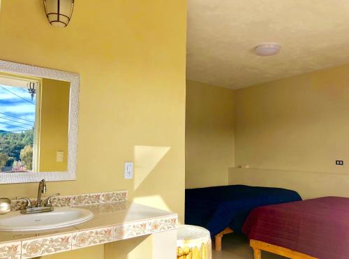 baño con lavabo y cama en Hotel JADE en Mesa Colorada