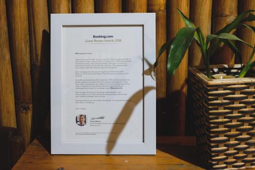 a framed document sitting on a table next to a potted plant at Glory Homestay in Yogyakarta