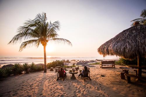 two people sitting at a table on the beach at Present Moment Retreat in Troncones