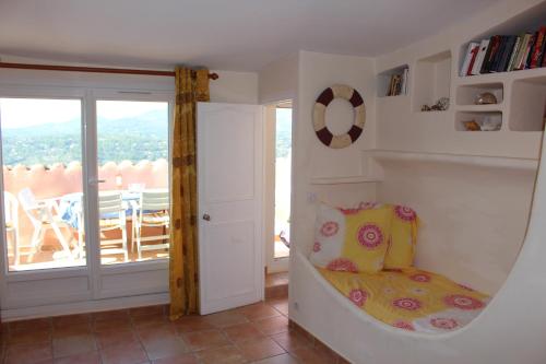 a room with a bed and a balcony at Au bon accueil in Fayence