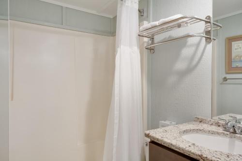 a bathroom with a sink and a shower curtain at Tar Heel Motel in Nags Head