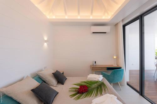 a bedroom with a large bed and a desk at Villa King Gustaf in Gustavia