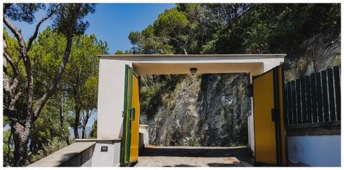 a building with yellow doors in front of a mountain at Casa Mia Casa di Charme in Santa Maria di Castellabate
