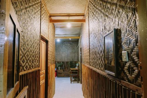 a hallway with wooden walls with art on it at Glory Homestay in Yogyakarta