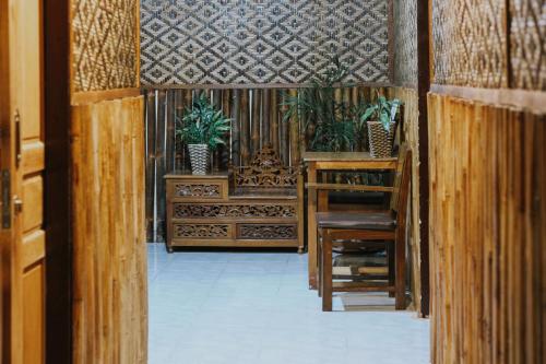a hallway with wooden walls and plants in a building at Glory Homestay in Yogyakarta
