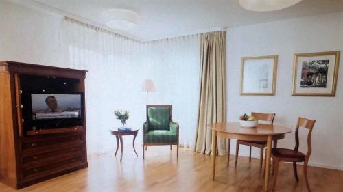 ein Wohnzimmer mit einem Tisch und einem TV in der Unterkunft FREE Apartment - Bei der Markthalle in Reutlingen