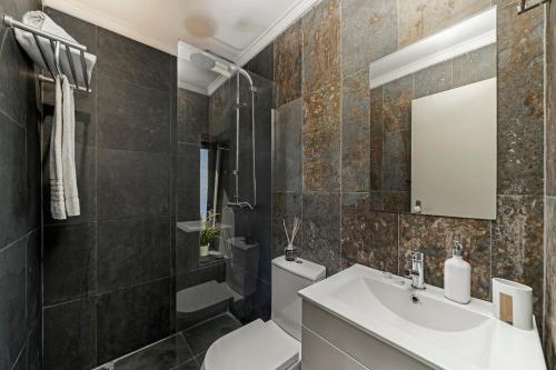 ein Badezimmer mit Waschbecken und Toilette in der Unterkunft Villa Clementina | Cliffs&Ocean | Heated Pool in Prazeres