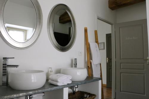Baño con 2 lavabos y espejo en la pared en Le Chai de Villiers en Villiers