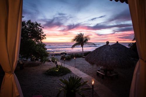 a view of a beach with a sunset at Present Moment Retreat in Troncones