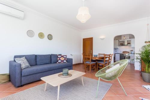 a living room with a blue couch and a table at Salema Family Home in Salema