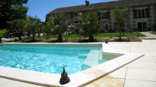 a swimming pool in front of a house at Le Chai de Villiers in Villiers