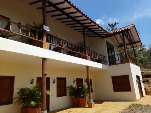 a house with a balcony with plants in front of it at Casa de Teja Barichara in Barichara