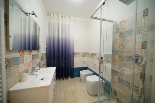 een badkamer met een wastafel, een toilet en een douche bij CASA VACANZE DA DANIELE in Marta