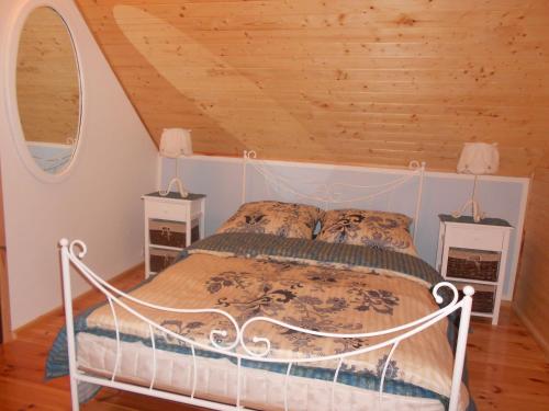 1 dormitorio con cama blanca y techo de madera en Domek na Wzgórzu, en Ryn