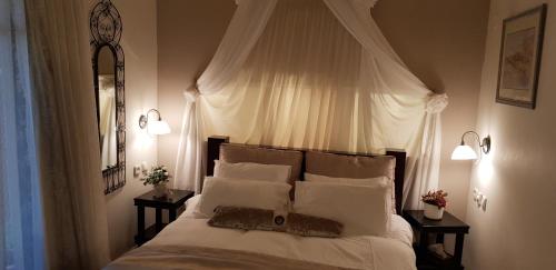 a bedroom with a white bed with two lamps at Rosh Pinat Noy in Rosh Pinna