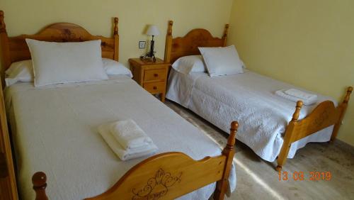 ポソ・アルコンにあるAlojamientos Guiradoのベッドルーム1室(白いシーツが備わるベッド2台付)